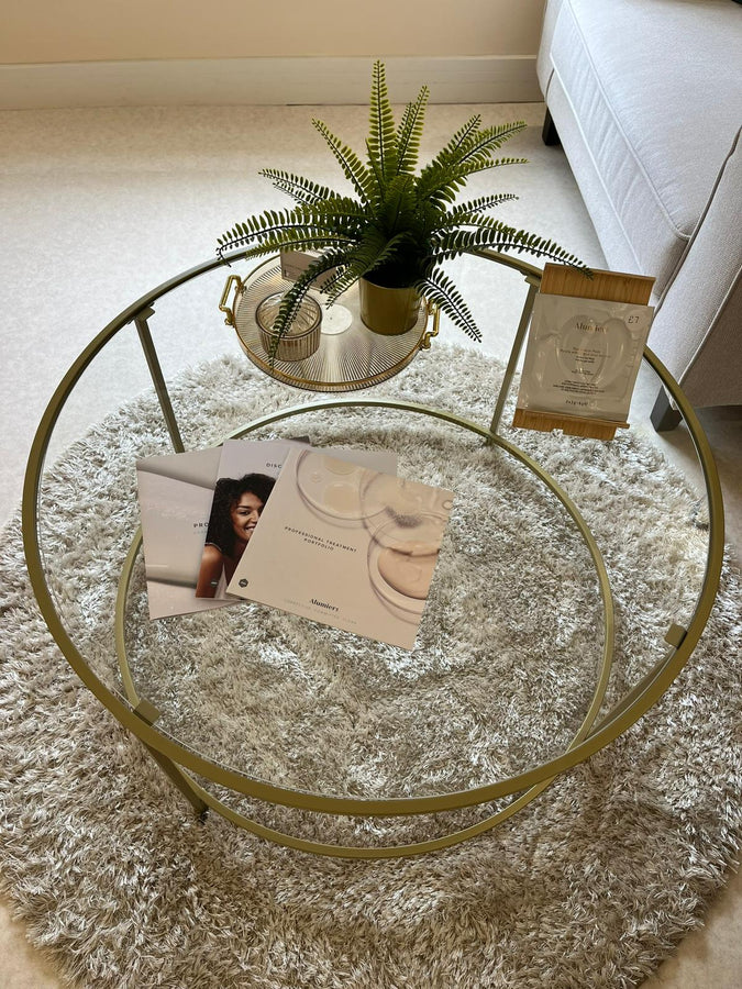 Round glass coffee table with decorative items on a carpeted floor