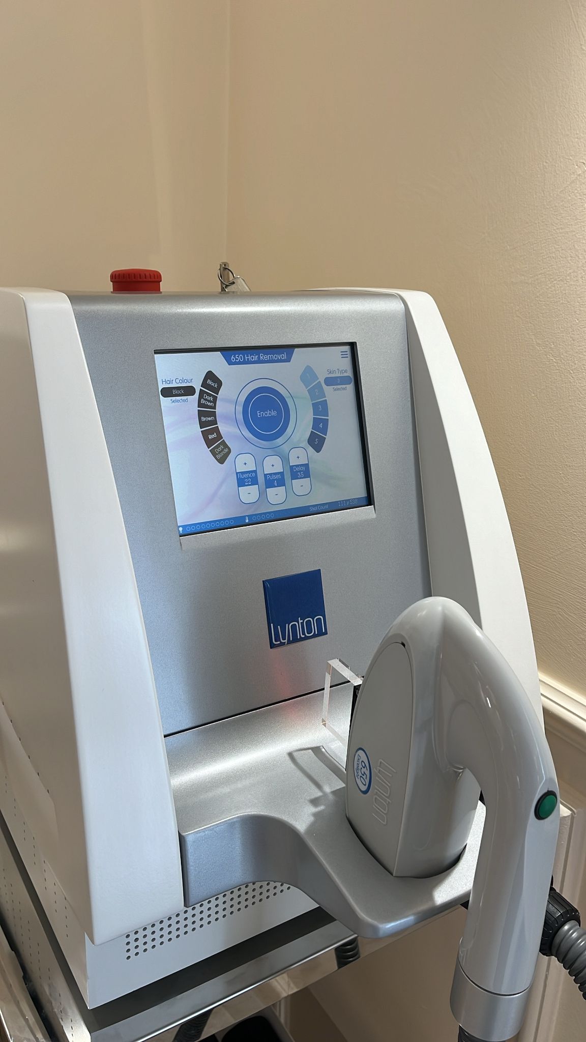 Laser machine with a screen and control panel on a beige wall background